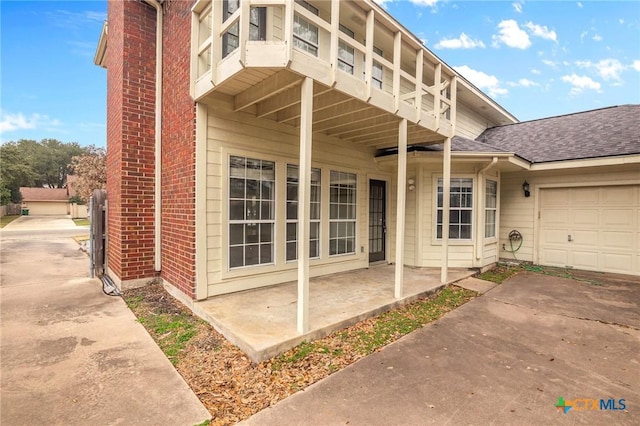 entrance to property featuring a garage and a patio area