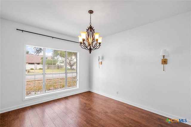 unfurnished dining area featuring dark hardwood / wood-style flooring and a chandelier