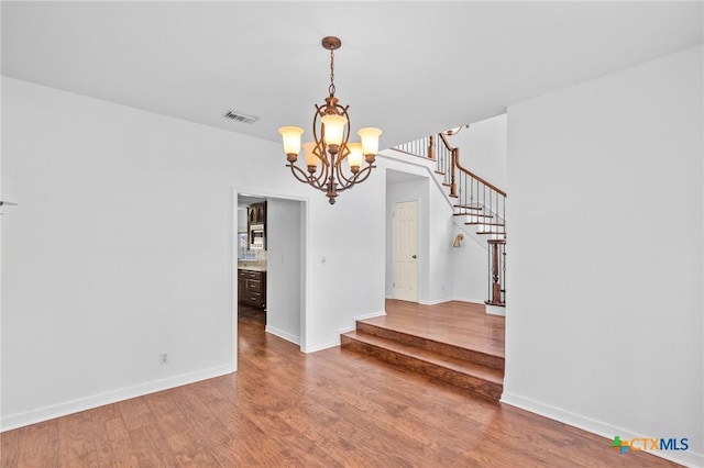 interior space with hardwood / wood-style floors and an inviting chandelier