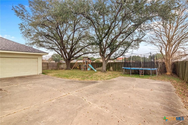 view of yard with a trampoline, a patio, and a playground