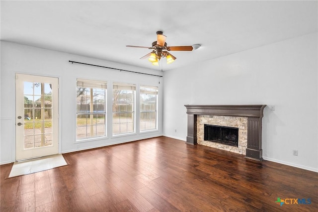 unfurnished living room featuring a fireplace, plenty of natural light, and dark hardwood / wood-style floors