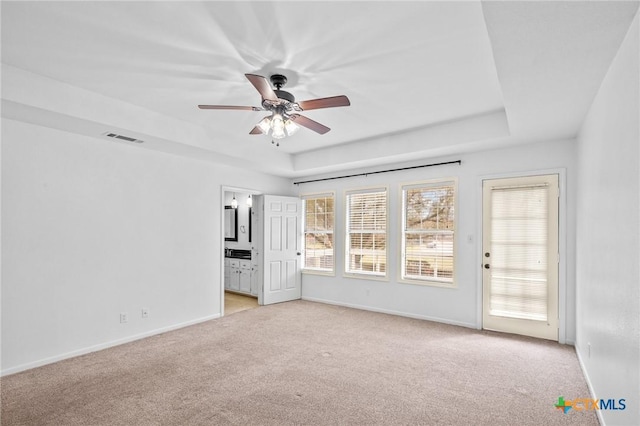 unfurnished room with light carpet, a raised ceiling, and ceiling fan