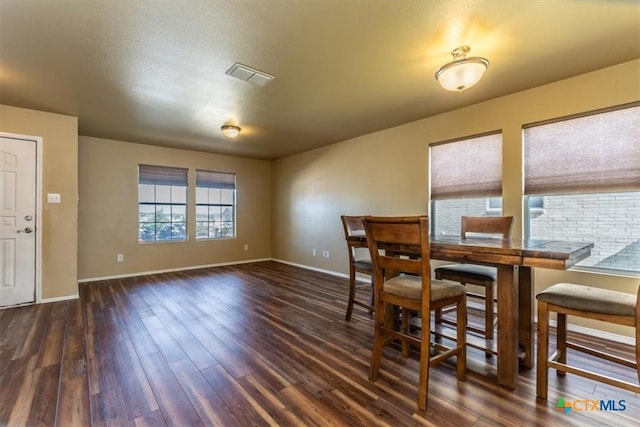 dining space with dark hardwood / wood-style flooring