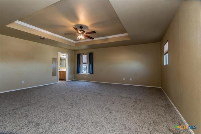 carpeted spare room with a tray ceiling, ceiling fan, and crown molding