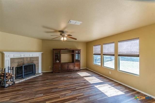 unfurnished living room featuring dark hardwood / wood-style floors, ceiling fan, and a fireplace