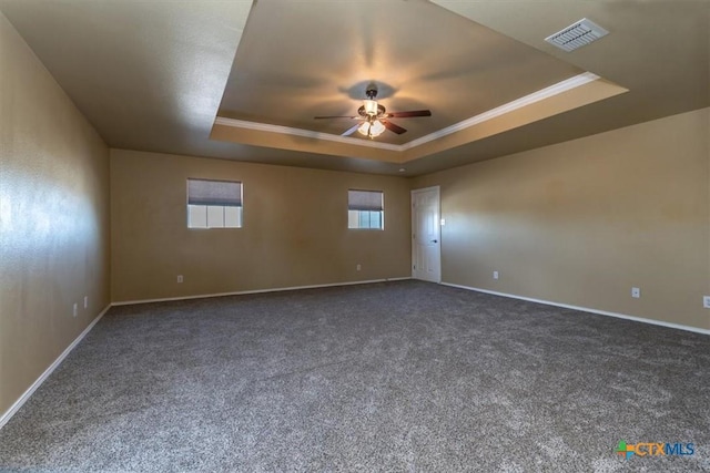 carpeted empty room with ceiling fan, ornamental molding, and a tray ceiling