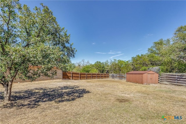 view of yard featuring an outbuilding, a storage shed, and fence