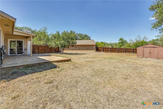 view of yard with a patio area, a storage unit, a fenced backyard, and an outdoor structure