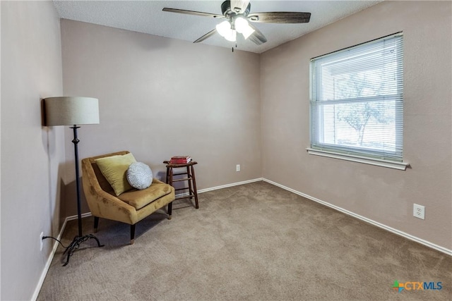 living area with carpet, baseboards, and ceiling fan