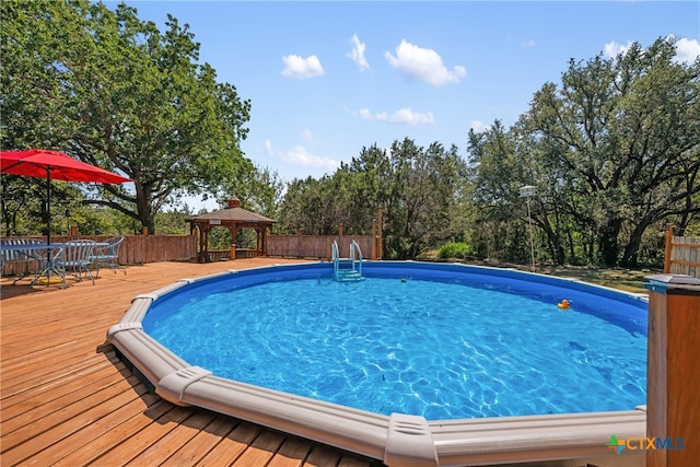 view of pool with a gazebo and a wooden deck