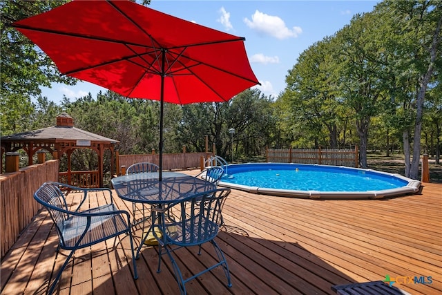 view of pool with a wooden deck and a gazebo