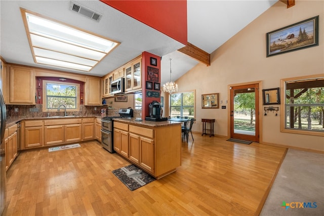 kitchen with sink, hanging light fixtures, kitchen peninsula, stainless steel appliances, and decorative backsplash