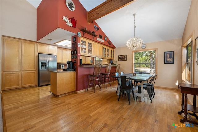 dining space with high vaulted ceiling, beamed ceiling, a chandelier, bar, and light hardwood / wood-style floors