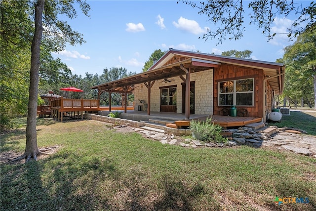 rear view of house with a patio, a deck, ceiling fan, and a lawn