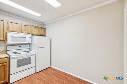 1624 Aquarena Springs Dr Unit G152, San Marcos, TX 78666 - kitchen featuring white appliances, crown molding, light wood-style flooring, light countertops, and baseboards