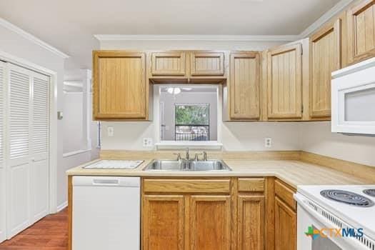 1624 Aquarena Springs Dr Unit G152, San Marcos, TX 78666 - kitchen featuring white appliances, a sink, light countertops, ornamental molding, and wood finished floors