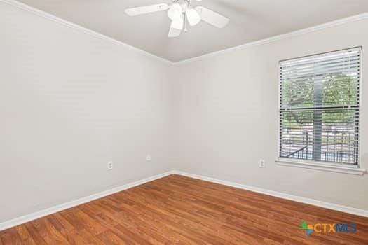 1624 Aquarena Springs Dr Unit G152, San Marcos, TX 78666 - empty room with crown molding, baseboards, wood finished floors, and ceiling fan
