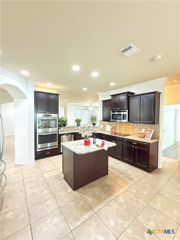 3312 Vineyard Trl, Harker Heights, TX 76548 - kitchen featuring appliances with stainless steel finishes, arched walkways, decorative backsplash, recessed lighting, and ornamental molding