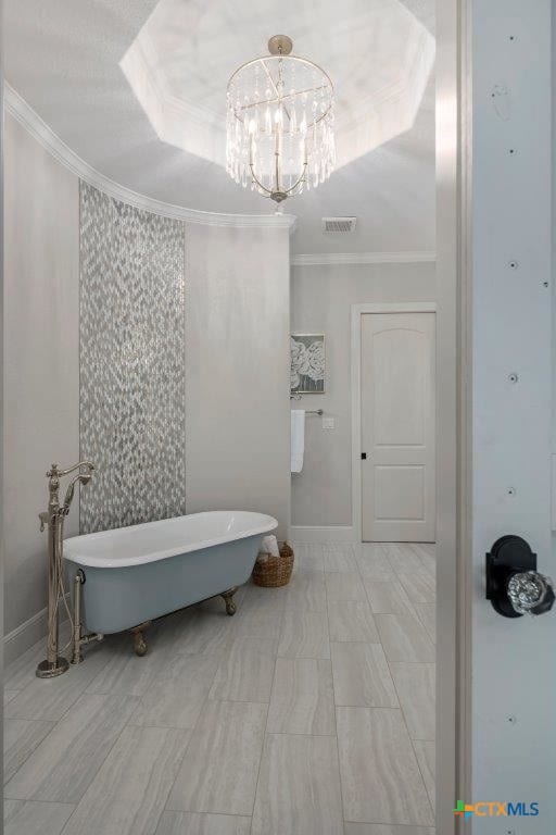 bathroom with a bathtub, a notable chandelier, crown molding, and a tray ceiling