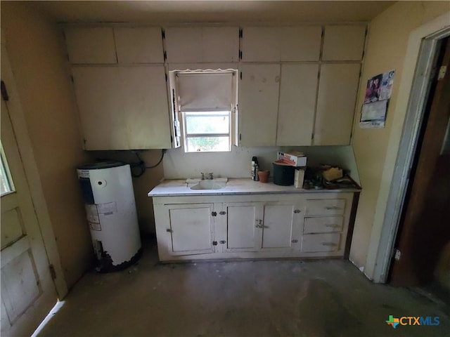 18581 State Highway 53, Temple, TX 76501 - kitchen featuring water heater, concrete flooring, light countertops, and white cabinetry