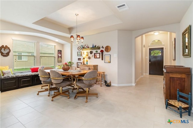 dining room featuring visible vents, arched walkways, light tile patterned floors, a raised ceiling, and a chandelier