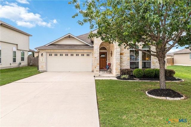 view of front of house with an attached garage, a front yard, driveway, and stone siding