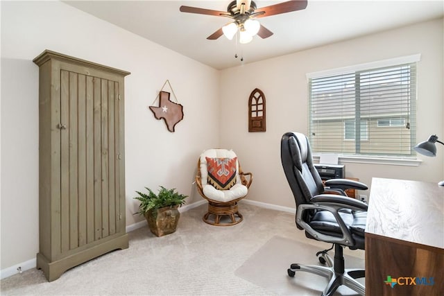 carpeted office with baseboards and a ceiling fan