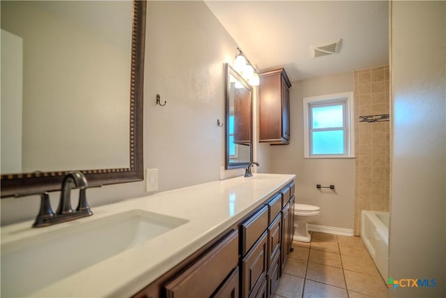 full bathroom featuring vanity, tiled shower / bath, tile patterned floors, and toilet