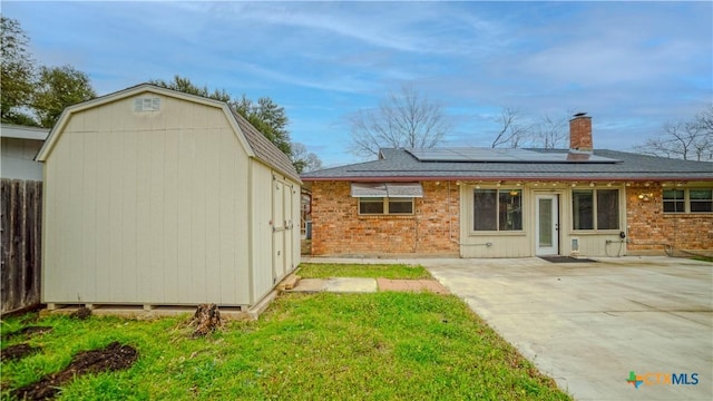 rear view of house featuring a yard, a patio, and solar panels