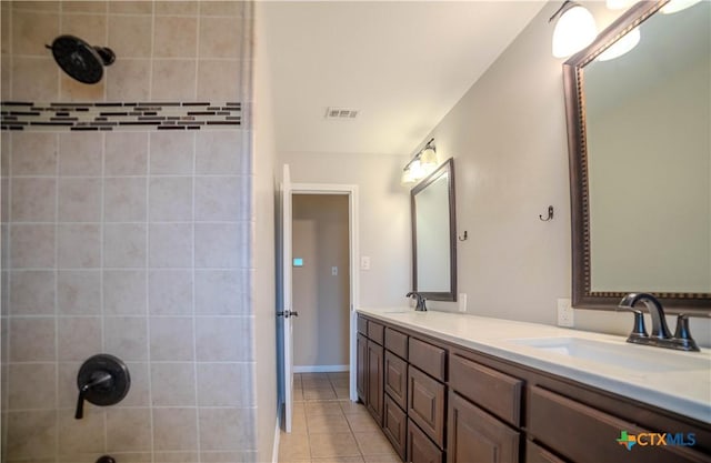 bathroom featuring vanity, tile patterned flooring, and tiled shower