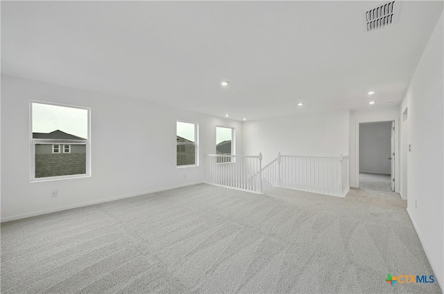 spare room with a healthy amount of sunlight and light colored carpet