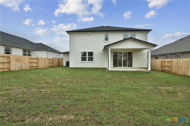 back of property featuring a yard and a patio