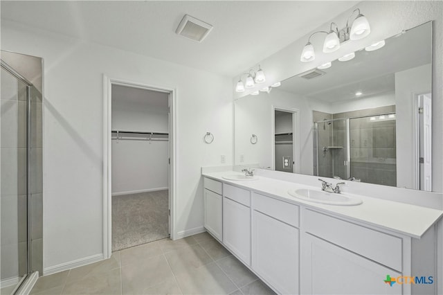 bathroom featuring tile patterned flooring, vanity, and walk in shower