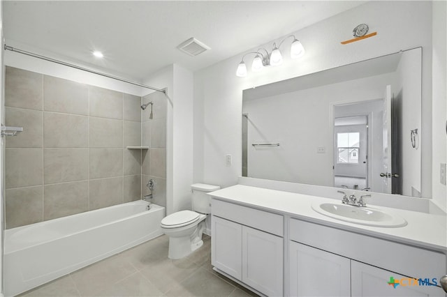 full bathroom featuring tile patterned flooring, tiled shower / bath combo, toilet, and vanity