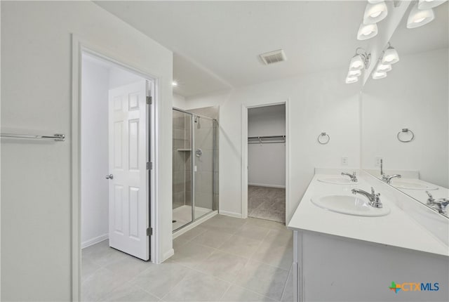 bathroom with tile patterned floors, vanity, and a shower with shower door