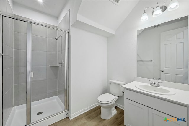 bathroom with vanity, vaulted ceiling, wood-type flooring, toilet, and a shower with shower door