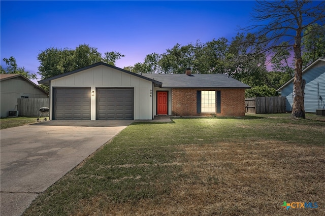 ranch-style house featuring a garage, a lawn, and central AC