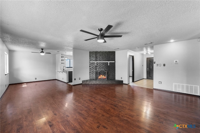 unfurnished living room with light wood-type flooring, a textured ceiling, sink, and ceiling fan