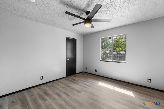 spare room featuring a textured ceiling, light hardwood / wood-style floors, and ceiling fan