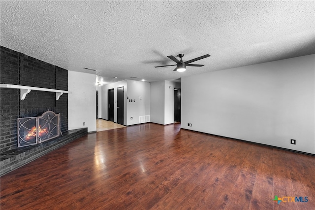 unfurnished living room featuring hardwood / wood-style floors, a fireplace, a textured ceiling, and ceiling fan