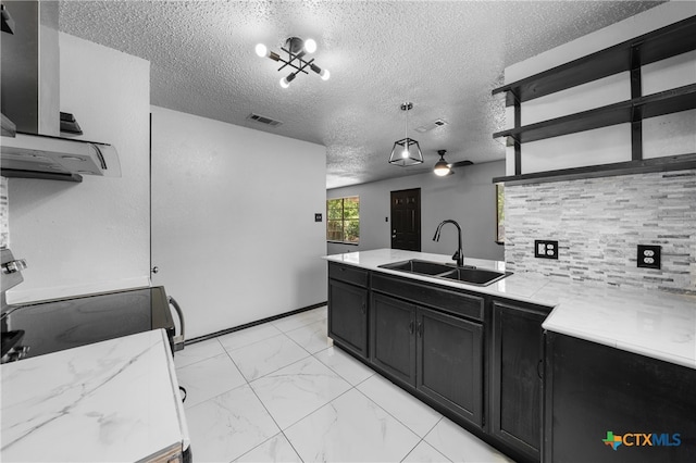 kitchen with sink, light stone counters, a textured ceiling, ventilation hood, and pendant lighting