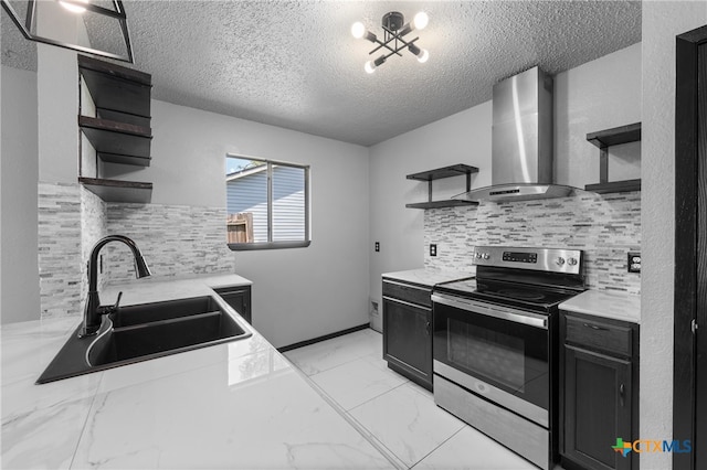 kitchen featuring sink, wall chimney exhaust hood, a textured ceiling, stainless steel range with electric stovetop, and decorative backsplash