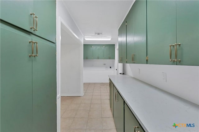 interior space featuring tile patterned flooring, visible vents, and a washtub
