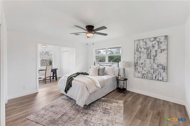 bedroom with visible vents, baseboards, and wood finished floors