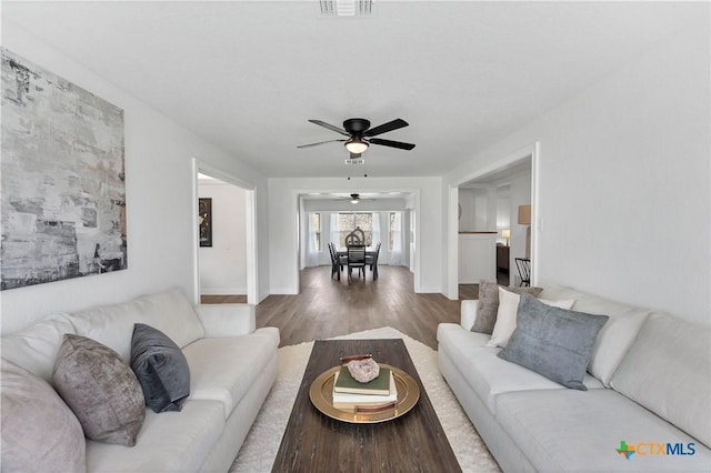 living area with visible vents and wood finished floors