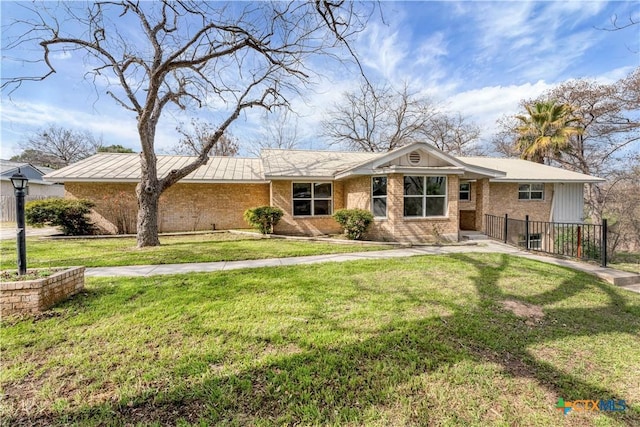 ranch-style home featuring brick siding and a front yard