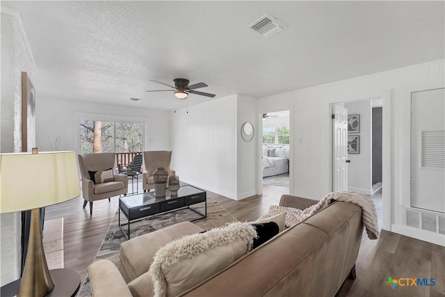 living area with visible vents, baseboards, and wood finished floors