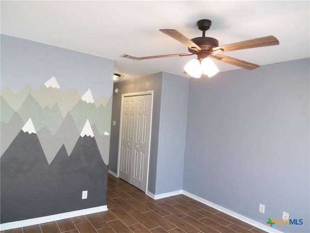 unfurnished room with ceiling fan and dark hardwood / wood-style floors