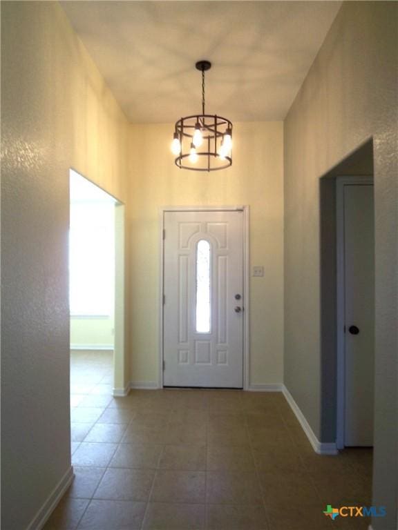 tiled foyer with an inviting chandelier