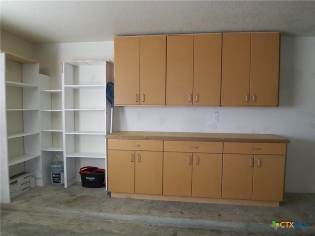 kitchen with light brown cabinetry and a textured ceiling